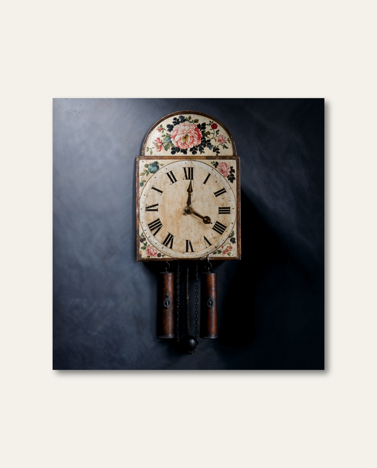 Klassische Schwarzwälder Schilderuhr mit antik patiniertem Zifferblatt, handgemalten Rosenmotiven und hängenden Gewichten vor dunkel strukturiertem Hintergrund. Eine punktuelle Ausleuchtung hebt die historischen Details der traditionellen Handwerkskunst edel und stilvoll hervor.