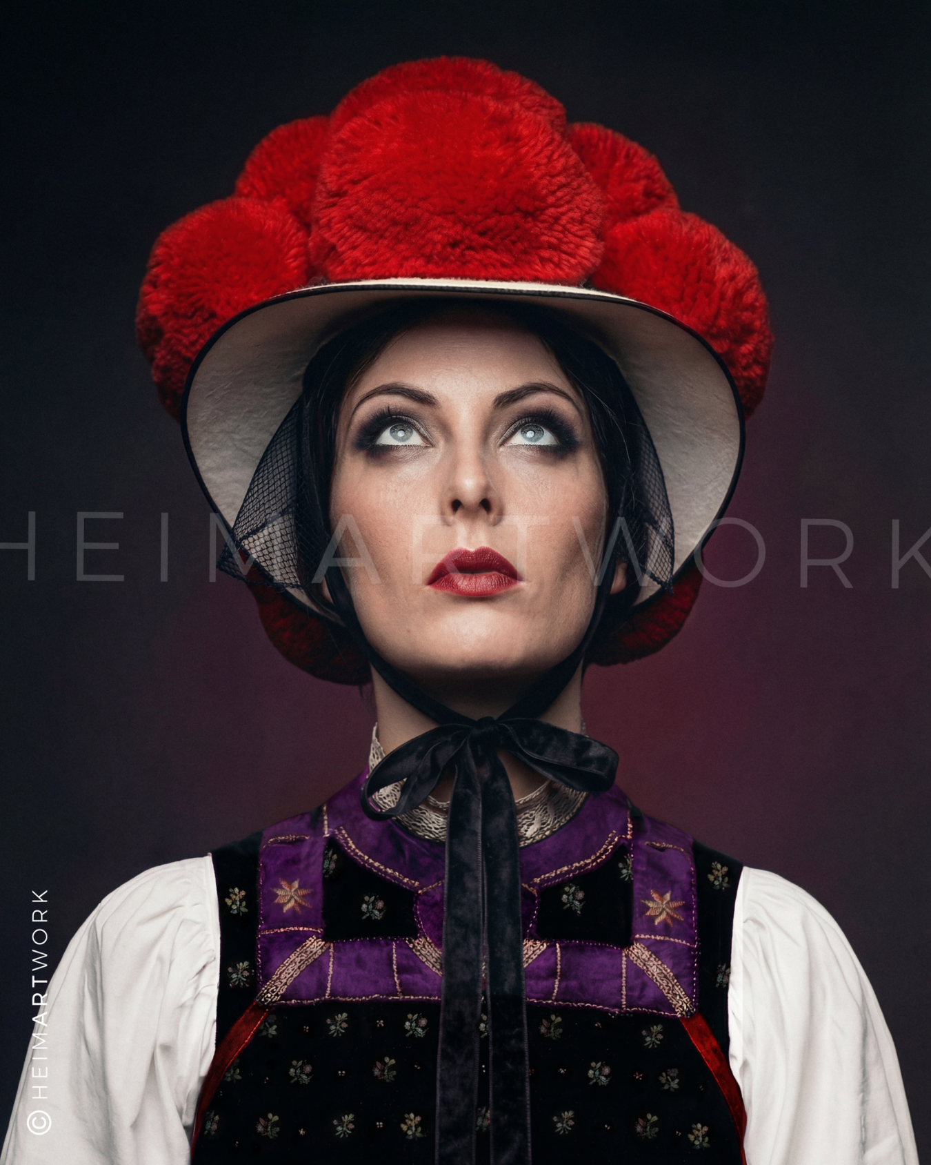 Detailreiches Porträt einer Frau in traditioneller Schwarzwälder Tracht mit einem prägnanten roten Bollenhut, violett-besticktem Mieder und weißer Bluse vor einem dunklen Hintergrund mit rotem Schimmer.