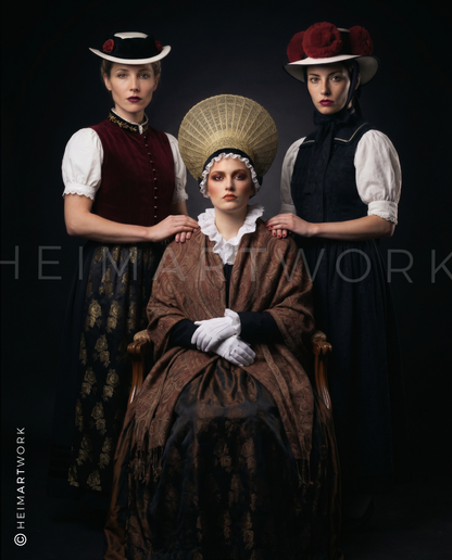 Drei Frauen in prachtvollen, traditionellen Schwarzwald-Trachten vor dunklem Hintergrund; die mittlere Dame trägt eine markante Goldhaube, flankiert von Frauen mit Rosenhut und klassischer Kopfbedeckung. Das Arrangement wirkt wie ein würdevolles, historisches Porträt mit moderner, kontrastreicher Lichtführung.