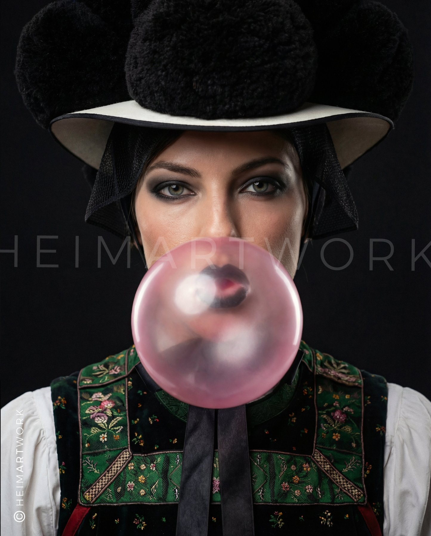 Detailreiches Porträt einer Frau in traditioneller Schwarzwälder Tracht mit schwarzem Bollenhut, die eine große rosa Kaugummiblase bläst, vor einem tiefdunklen Hintergrund.