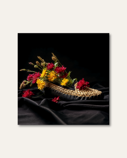 Kunstvolles Schwarzwald Wandbild von HEIMARTWORK mit geflochtenem Strohschuh, farbenfrohen Blüten und edler Lichtstimmung auf dunklem Grund.