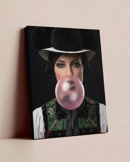 Ein fertig gerahmtes Schwarzwald Leinwandbild mit einem  modernen Motiv einer Frau mit Bollenhut und Kaugummi, das lässig auf dem Boden an einer einfarbigen Wand lehnt.