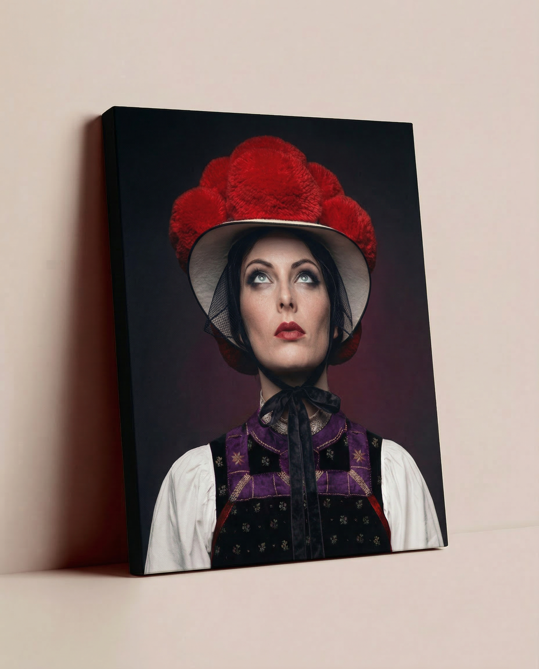 Ein fertig bespanntes Leinwandbild mit dem Schwarzwald-Bollenhut-Motiv, das lässig auf dem Boden an einer einfarbigen, beige-gestrichenen Wand lehnt.